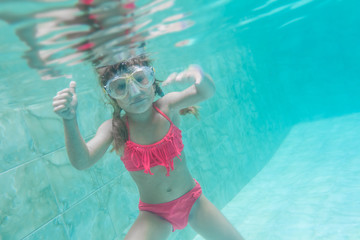 child girl swimming underwater in mask