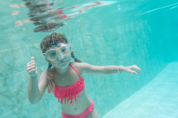 child girl swimming underwater in mask