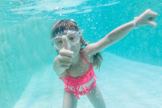 child girl swimming underwater in mask