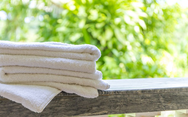 rolled beach or spa towels on natural green background