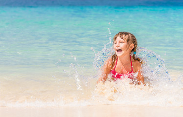 young happy child girl having fun in water, tropical summer vaca