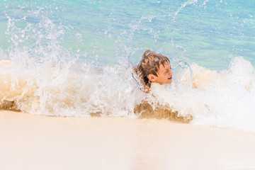 young happy child boy having fun in water, tropical summer vacat
