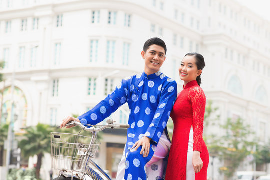 Portrait of beautiful Vietnamese couple posing on bicycle