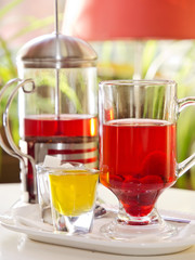 teapot and cup with berry tea with raspberries and honey