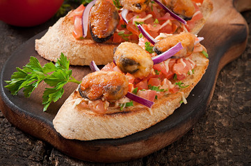 Bruschetta with mussels, cheese and tomatoes