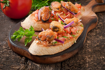 Bruschetta with mussels, cheese and tomatoes