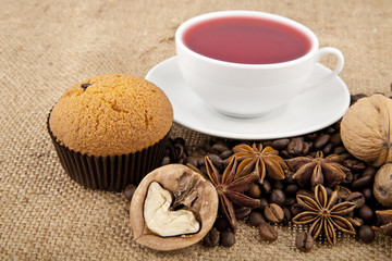 cakes, grains of coffee, seasonings and cup of floral tea