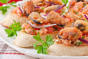 Bruschetta with mussels, cheese and tomatoes