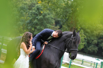 Bride and groom at stud black horse