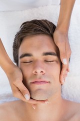 Fototapeta na wymiar Man receiving facial massage at spa center
