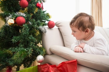 Obraz na płótnie Canvas Cute baby boy on couch at christmas