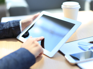 Close-up of businesswoman holding digital tablet and cup coffee
