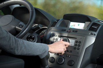 Woman adjusting a knob in her car
