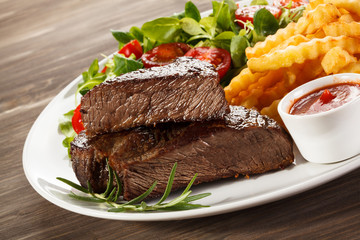 Beefsteaks, French fries and vegetables
