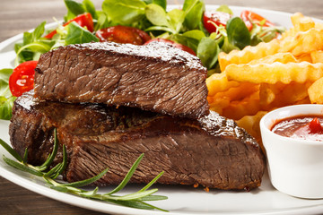 Beefsteaks, French fries and vegetables