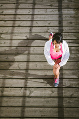 Fototapeta na wymiar Young female athlete stretching before running
