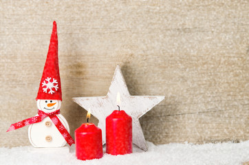 schneemann mit adventskerzen im schnee