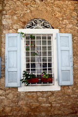 Fototapeta na wymiar Window with grey painted wood louvre shutters