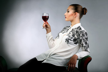 Молодая девушка на диване с бокалом вина