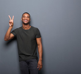 Young man smiling showing hand peace sign