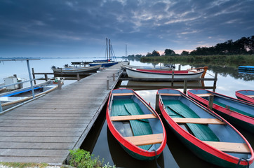Fototapeta na wymiar red boats on lake harbor