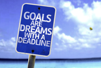 Goals Are Dreams With a Deadline sign with a beach