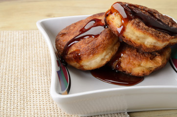Fritters of cottage cheese with honey on a white plate