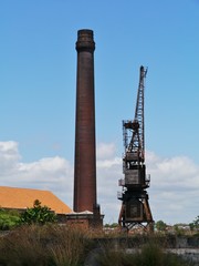 Fototapeta na wymiar Historic harbor crane and a chimney on Cockatoo Island