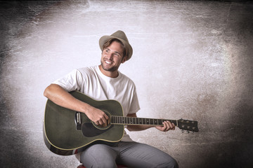 Obraz premium Handsome young musician playing the guitar
