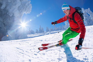 Skier skiing in high mountains against blue sky