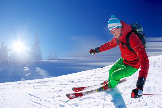 Skier skiing in high mountains against blue sky