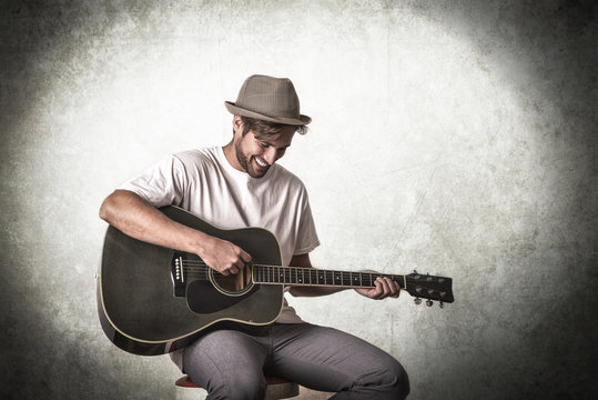 Handsome young musician playing the guitar