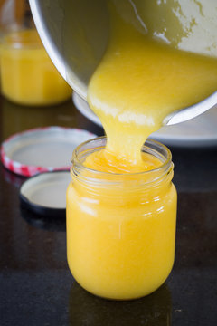 Pouring the homemade lemon curd into the jars