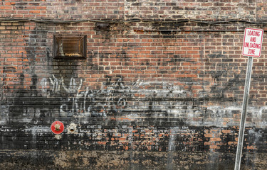 Vieux fond de mur de briques encombré avec Graffiti