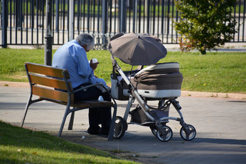 Obraz na płótnie Canvas abuelo dando de comer a su nieto en un parque