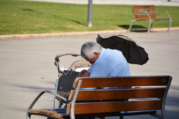Obraz premium abuelo dando de comer a su nieto en un parque