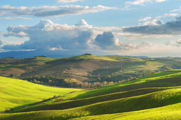 Fototapeta na wymiar Tuscan landscape with clouds and green fields, Italy