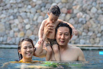 Fototapeta premium Happy Asian father and his child have fun at pool.