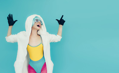 Screaming crazy girl in hoodie on a blue background.