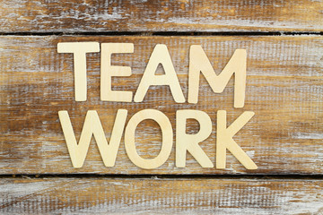 "Team work" written with wooden letters on rustic wooden surface