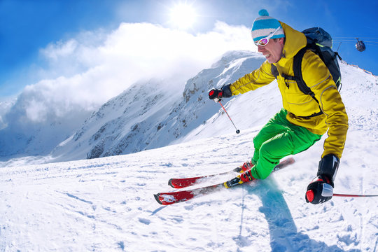 Skier skiing in high mountains against blue sky