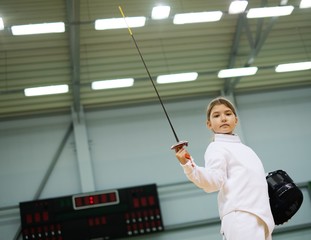 Little girl fencer with epee and mask