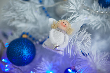 Fototapeta na wymiar Christmas toys in the form of an angel hanging on the tree next