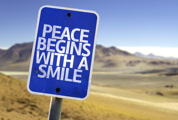 Peace Begins With a Smile sign with a desert background - obrazy, fototapety, plakaty