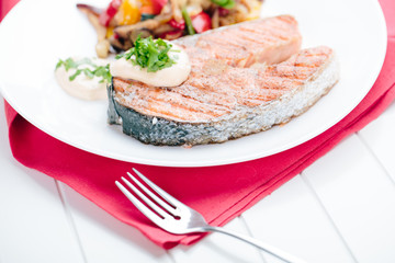Grilled Salmon with Fresh vegetables on red background