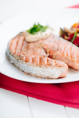 Grilled Salmon with Fresh vegetables on red background