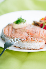 Grilled Salmon with Fresh vegetables on green background