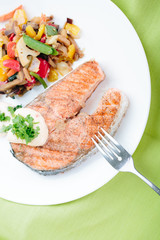 Grilled Salmon with Fresh vegetables on green background