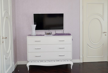 White dresser in a bedroom. Modern classics with rococo elements