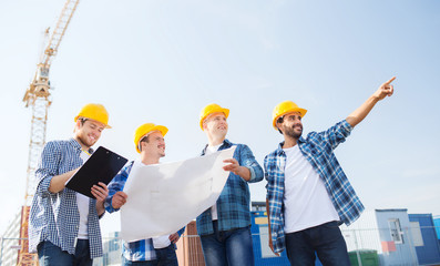 group of builders with tablet pc and blueprint